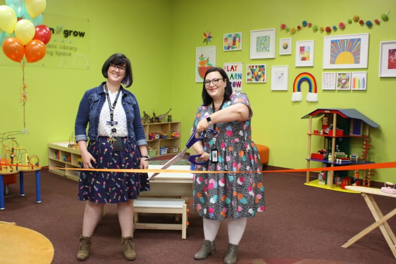 Two presenters in a brightly decorated children's room