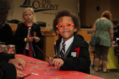 A smiling boy at a craft table in the library