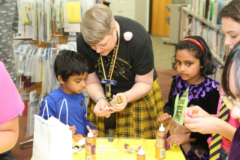 A volunteer helping children with a hands-on activity