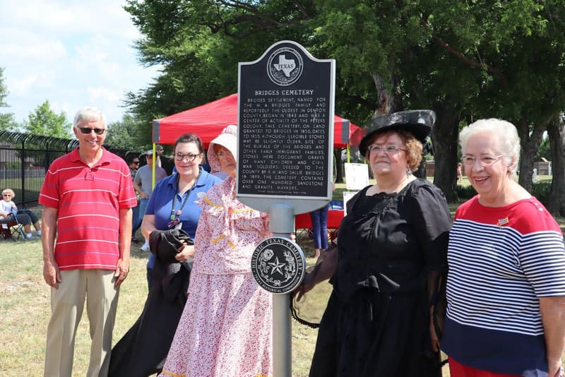 A group gathered beside a historical marker