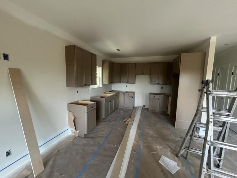 Kitchen with new shaker cabinets installed and floors protected during construction
